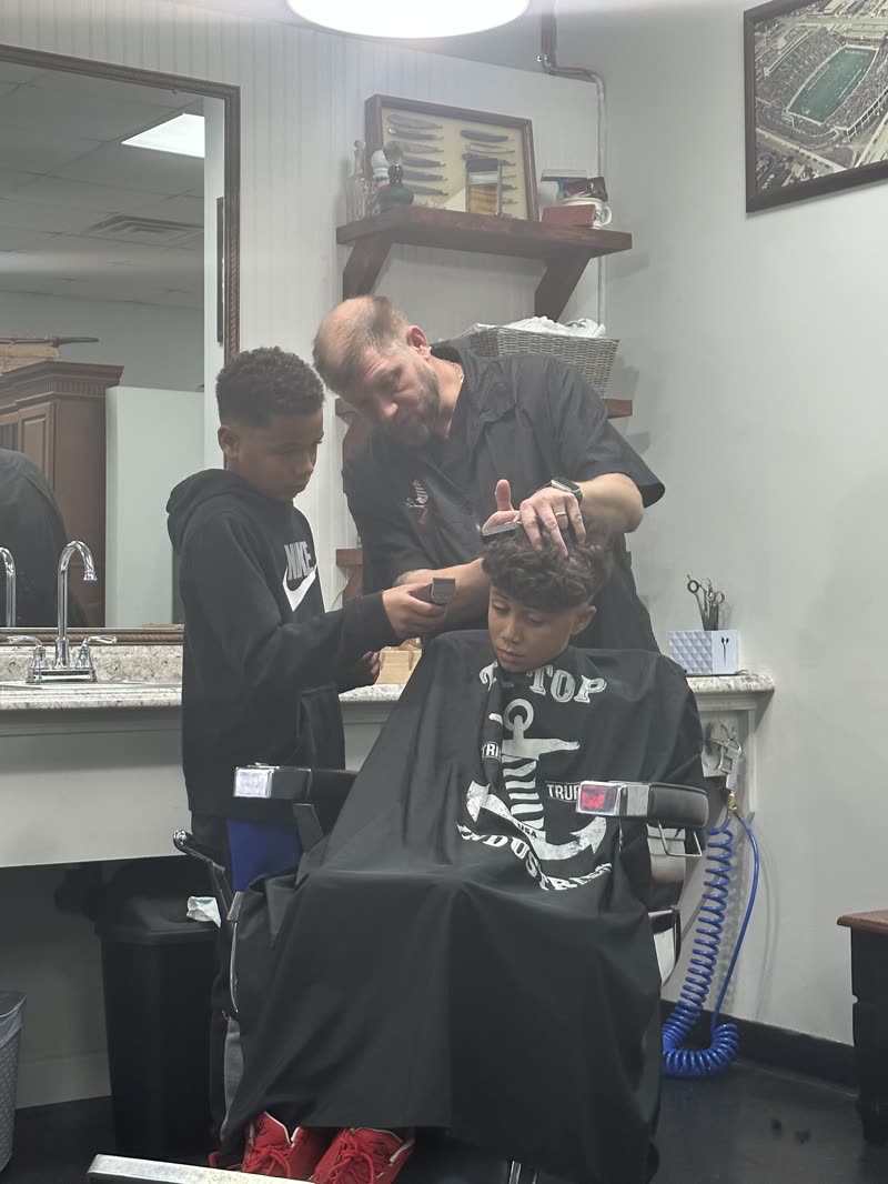 Client mid-cut, barber working scissors.