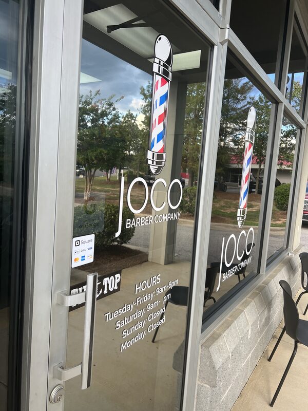 The hours decal on the glass beside the front door.